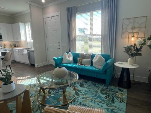 Bright living room featuring a teal couch, coffee table, and stylish decor.